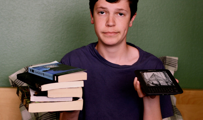 a guy holding books and a kindle